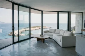 Salon d'appartement de luxe avec vue panoramique sur la mer Méditerranée depuis de grandes baies vitrées